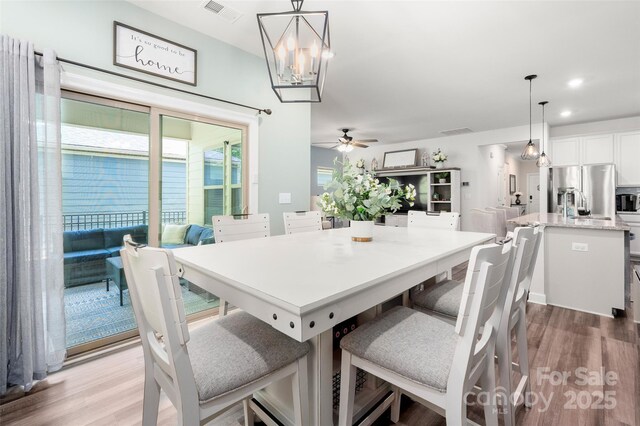 7530 Porrera St, Charlotte, NC 28214 - dining room with wood finished floors, a ceiling fan, a chandelier, and recessed lighting