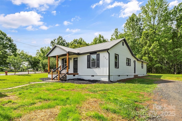 modern farmhouse featuring crawl space, metal roof, a front yard, and covered porch