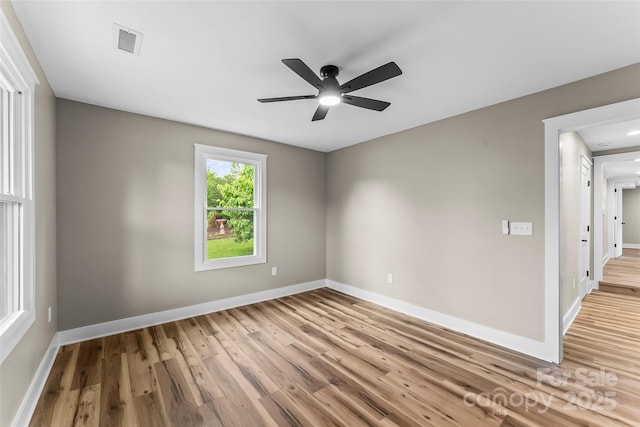 spare room with a ceiling fan, wood finished floors, and baseboards
