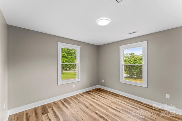 spare room with light wood finished floors and baseboards