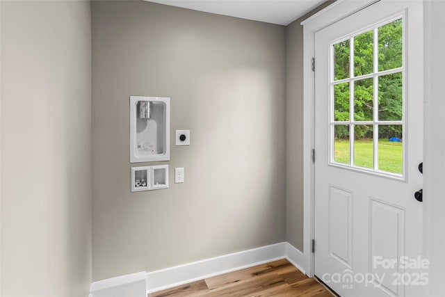 washroom with hookup for an electric dryer, hookup for a washing machine, baseboards, and light wood-style flooring
