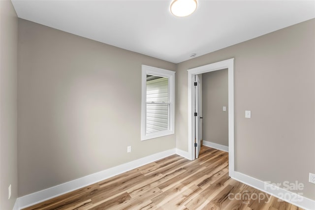 spare room with light wood-style flooring and baseboards