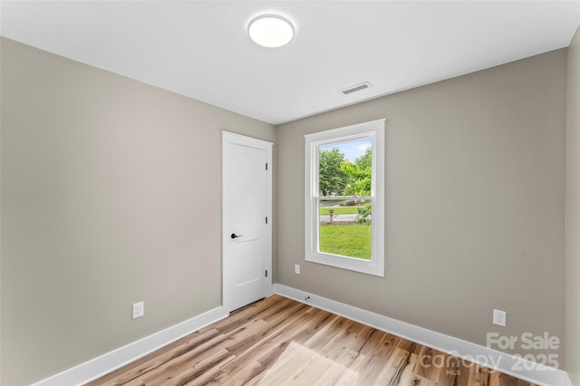 spare room with light wood finished floors and baseboards
