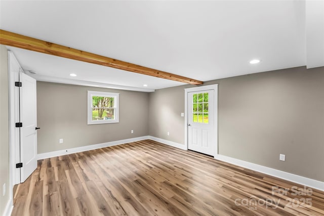 spare room featuring light wood-style flooring, recessed lighting, plenty of natural light, baseboards, and beamed ceiling