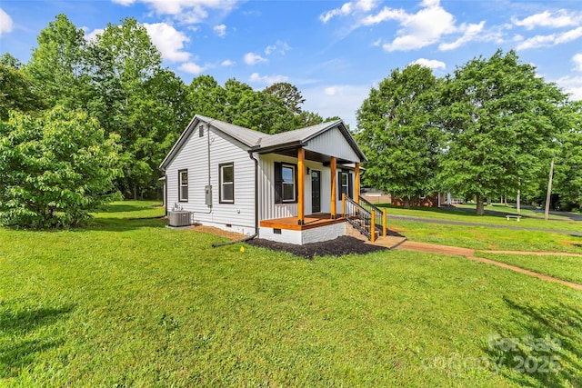 view of front of house featuring crawl space, a front yard, central AC unit, view of scattered trees, and metal roof