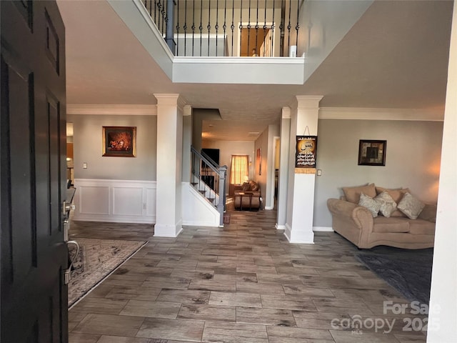 5227 Eagle Creek Dr, Charlotte, NC 28269 - entryway featuring ornamental molding, stairway, a towering ceiling, baseboards, and wainscoting