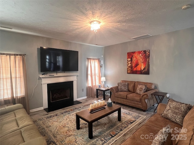 5227 Eagle Creek Dr, Charlotte, NC 28269 - living room with wood finished floors, healthy amount of natural light, a textured ceiling, and a fireplace with raised hearth
