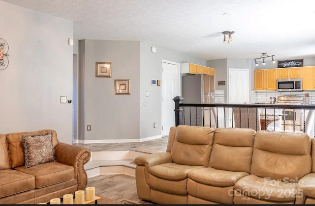 5227 Eagle Creek Dr, Charlotte, NC 28269 - living room with light wood-type flooring, baseboards, and a textured ceiling