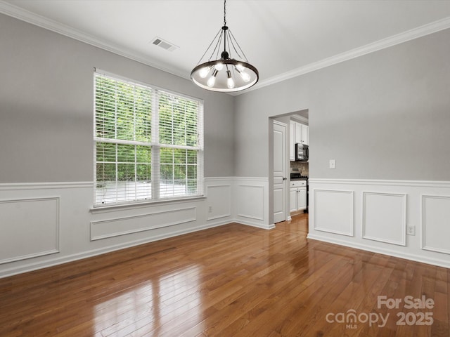 3038 Sterling Ct, Fort Mill, SC 29707 - spare room with a chandelier, a wainscoted wall, crown molding, hardwood / wood-style flooring, and a decorative wall