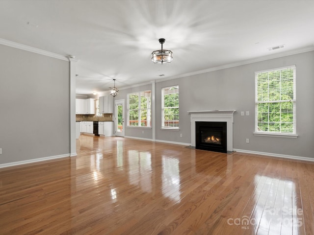 3038 Sterling Ct, Fort Mill, SC 29707 - unfurnished living room with a fireplace with flush hearth, light wood-type flooring, baseboards, crown molding, and a chandelier