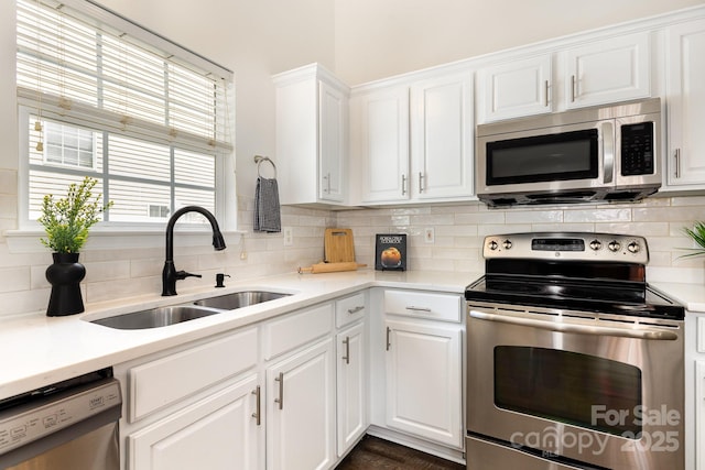 1776 Baylor Dr, Rock Hill, SC 29732 - kitchen with stainless steel appliances, a sink, white cabinetry, tasteful backsplash, and light countertops