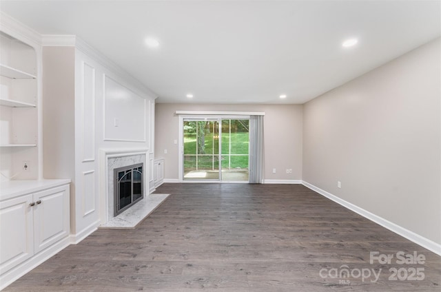 unfurnished living room featuring a fireplace, dark wood finished floors, baseboards, and recessed lighting