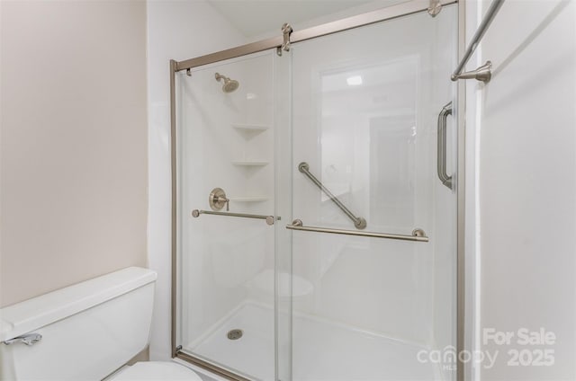 bathroom with a shower stall and toilet