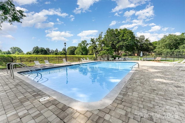 community pool featuring a patio area and view of scattered trees