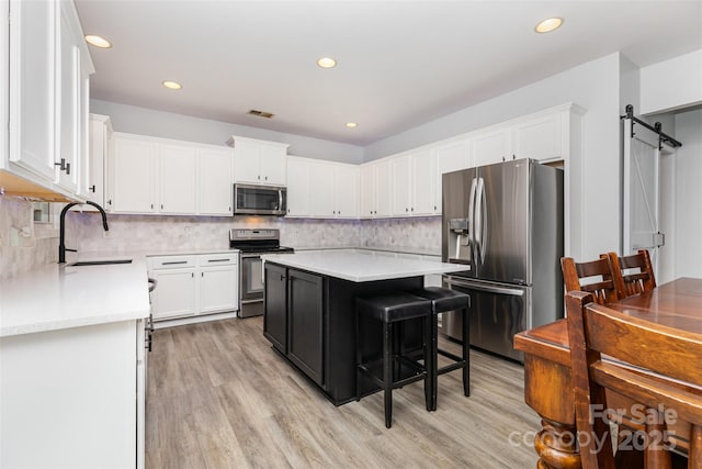 9593 Indian Beech Ave NW, Concord, NC 28027 - kitchen with stainless steel appliances, a sink, light countertops, white cabinetry, and recessed lighting