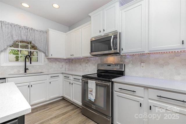 9593 Indian Beech Ave NW, Concord, NC 28027 - kitchen with stainless steel appliances, a sink, white cabinetry, tasteful backsplash, and recessed lighting