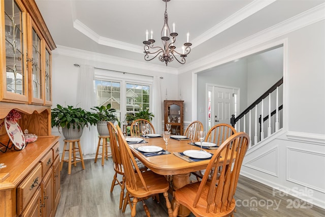 9593 Indian Beech Ave NW, Concord, NC 28027 - dining room with light wood finished floors, a chandelier, a raised ceiling, and crown molding