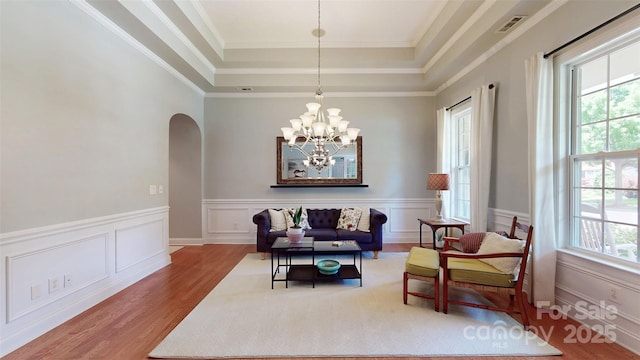 8605 Soaring Eagle Ln, Waxhaw, NC 28173 - sitting room featuring healthy amount of natural light, arched walkways, wood finished floors, a chandelier, and a wainscoted wall