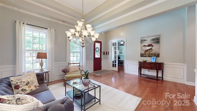 8605 Soaring Eagle Ln, Waxhaw, NC 28173 - living room featuring a chandelier, healthy amount of natural light, wood finished floors, a wainscoted wall, and a decorative wall