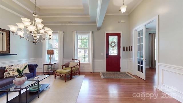 8605 Soaring Eagle Ln, Waxhaw, NC 28173 - entryway with wood finished floors, a wainscoted wall, a decorative wall, a raised ceiling, and a chandelier