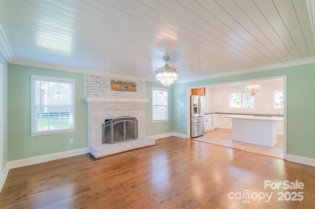 3921 Bon Rea Dr, Charlotte, NC 28226 - unfurnished living room with a chandelier, plenty of natural light, ornamental molding, a brick fireplace, and baseboards