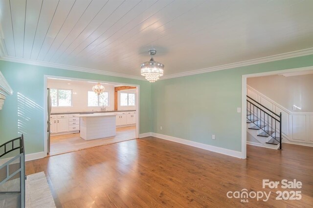 3921 Bon Rea Dr, Charlotte, NC 28226 - unfurnished living room featuring a chandelier, crown molding, stairway, light wood-type flooring, and a sink