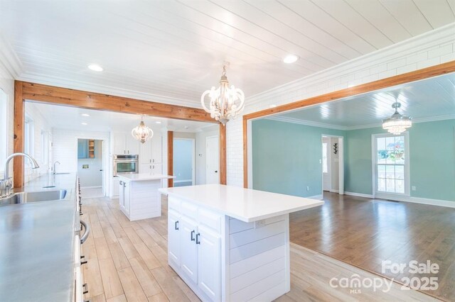 3921 Bon Rea Dr, Charlotte, NC 28226 - kitchen with a chandelier, a sink, stainless steel oven, a center island, and light wood-style floors