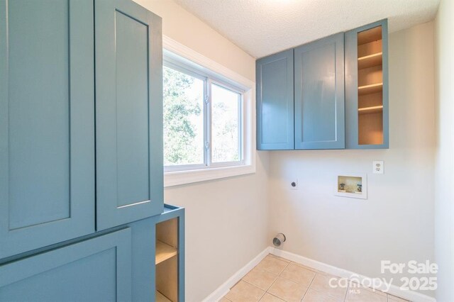 3921 Bon Rea Dr, Charlotte, NC 28226 - laundry area with cabinet space, electric dryer hookup, washer hookup, baseboards, and light tile patterned flooring