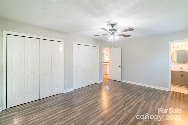 3921 Bon Rea Dr, Charlotte, NC 28226 - unfurnished bedroom featuring multiple closets, baseboards, wood finished floors, ensuite bathroom, and a sink