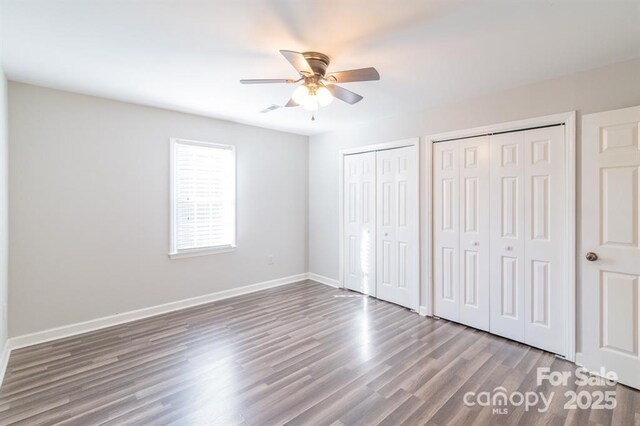 3921 Bon Rea Dr, Charlotte, NC 28226 - unfurnished bedroom with two closets, wood finished floors, baseboards, and a ceiling fan