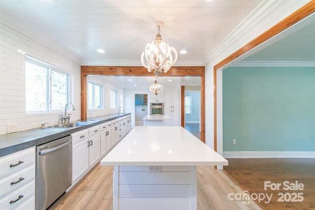 3921 Bon Rea Dr, Charlotte, NC 28226 - kitchen featuring appliances with stainless steel finishes, a sink, a center island, a chandelier, and light wood finished floors