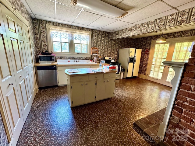 4689 Lakeview Acres Rd, Valdese, NC 28690 - kitchen featuring wallpapered walls, appliances with stainless steel finishes, a drop ceiling, light countertops, and dark floors