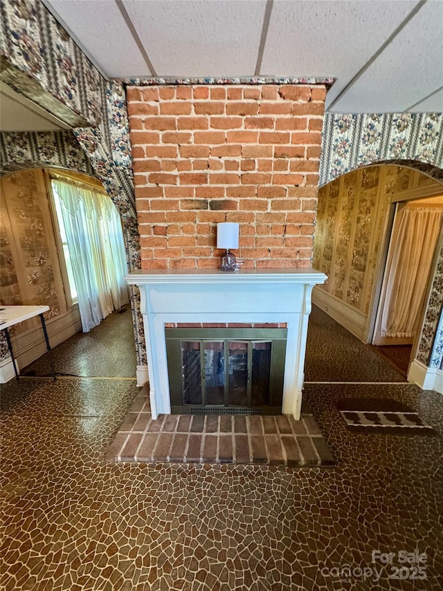 4689 Lakeview Acres Rd, Valdese, NC 28690 - detailed view of a brick fireplace, wallpapered walls, arched walkways, and a textured ceiling