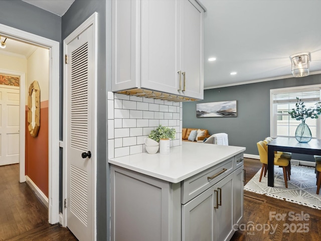 827 Fairbanks Rd, Charlotte, NC 28210 - kitchen featuring crown molding, dark wood-style flooring, backsplash, light countertops, and baseboards