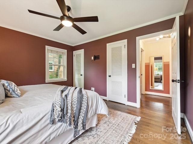 827 Fairbanks Rd, Charlotte, NC 28210 - bedroom featuring wood finished floors, ornamental molding, baseboards, two closets, and ceiling fan