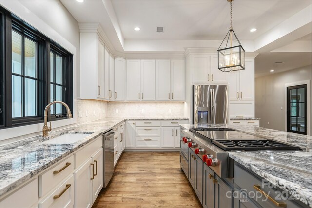 467 Dale Rd, Spruce Pine, NC 28777 - kitchen featuring stainless steel appliances, a sink, white cabinets, light wood-style floors, and decorative backsplash