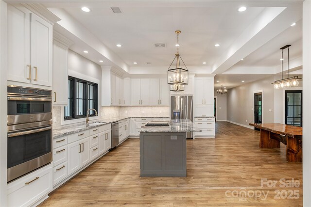 467 Dale Rd, Spruce Pine, NC 28777 - kitchen with appliances with stainless steel finishes, a chandelier, a sink, a kitchen island, and backsplash