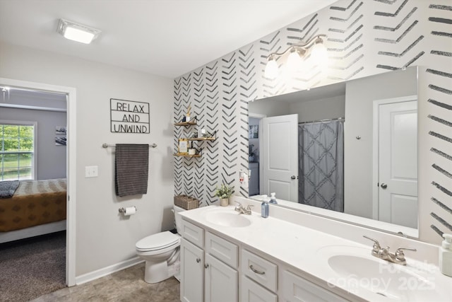 835 Jet St, Kannapolis, NC 28081 - bathroom featuring wallpapered walls, toilet, baseboards, double vanity, and an accent wall