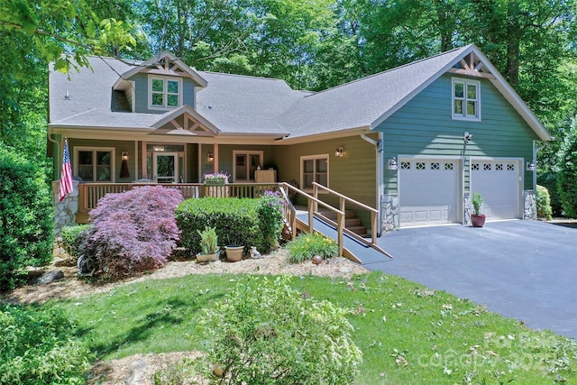399 Stepping Stone Ln, Waynesville, NC 28786 - view of front facade featuring asphalt driveway, a porch, an attached garage, and a front lawn