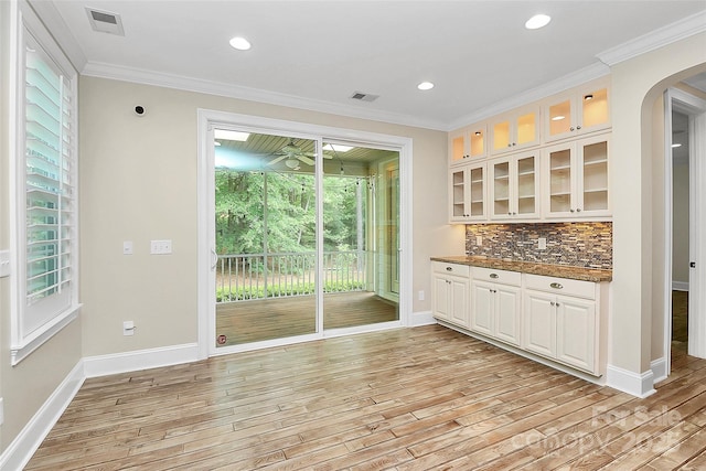11052 Preservation Park Dr, Charlotte, NC 28214 - bar area with arched walkways, light wood-type flooring, decorative backsplash, baseboards, and ornamental molding