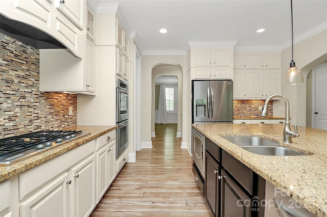 11052 Preservation Park Dr, Charlotte, NC 28214 - kitchen with stainless steel appliances, arched walkways, a sink, range hood, and hanging light fixtures