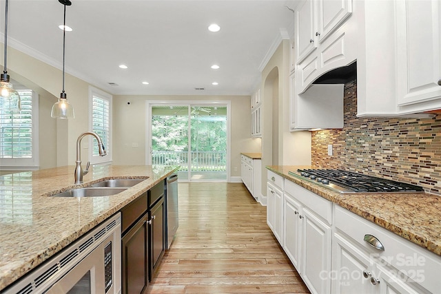 11052 Preservation Park Dr, Charlotte, NC 28214 - kitchen with a sink, appliances with stainless steel finishes, ornamental molding, light wood finished floors, and white cabinets