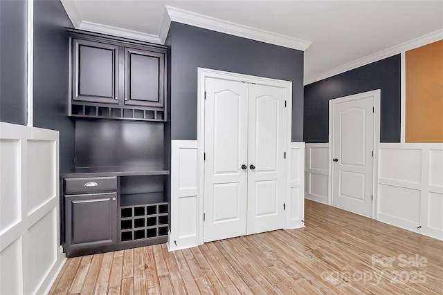 11052 Preservation Park Dr, Charlotte, NC 28214 - unfurnished bedroom with ornamental molding, light wood-style floors, a closet, a decorative wall, and a wainscoted wall