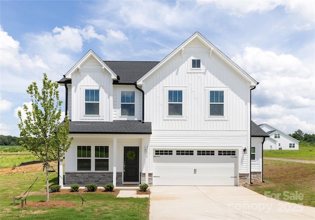 32616 Millingport Rd Unit 7144, New London, NC 28127 - view of front of home with board and batten siding, stone siding, concrete driveway, a front yard, and a garage