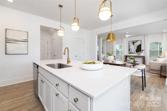 32616 Millingport Rd Unit 7144, New London, NC 28127 - kitchen featuring open floor plan, light wood finished floors, white cabinetry, hanging light fixtures, and a kitchen island with sink