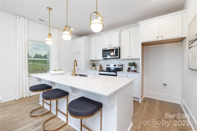 32616 Millingport Rd Unit 7144, New London, NC 28127 - kitchen featuring appliances with stainless steel finishes, backsplash, light wood finished floors, and white cabinets