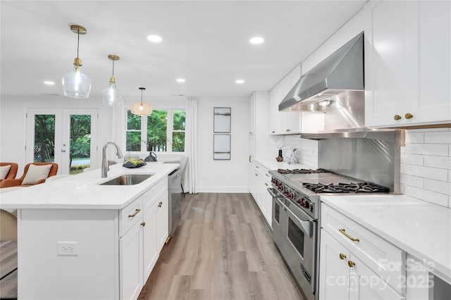 9826 Meringue Pl Unit 15, Charlotte, NC 28270 - kitchen featuring a sink, wall chimney exhaust hood, appliances with stainless steel finishes, light wood-style flooring, and recessed lighting