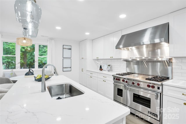 9826 Meringue Pl Unit 15, Charlotte, NC 28270 - kitchen with range with two ovens, a sink, wall chimney range hood, recessed lighting, and decorative light fixtures