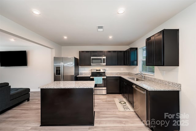 2037 Langer St, Charlotte, NC 28214 - kitchen featuring stainless steel appliances, a sink, a center island, light stone countertops, and light wood-style flooring