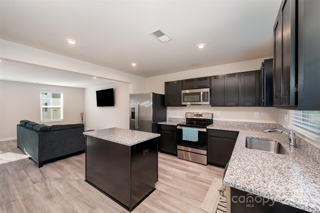 2037 Langer St, Charlotte, NC 28214 - kitchen with appliances with stainless steel finishes, a sink, a kitchen island, light wood-type flooring, and open floor plan